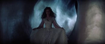 Movie still from “Krull” (1983), directed by Peter Yates – A woman in a white dress standing in front of a moon; Wide shot, Low angle