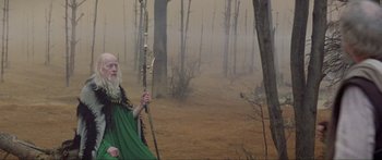 Movie still from “Krull” (1983), directed by Peter Yates – An old man with a long white beard holding an arrow; Wide shot, High angle