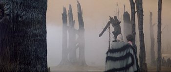 Movie still from “Krull” (1983), directed by Peter Yates – Trees in the middle of a foggy field; Extreme Wide shot, Low angle