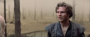 Movie still from “Krull” (1983), directed by Peter Yates – A man in a leather jacket looks at the camera; Close Up shot, Over the shoulder angle