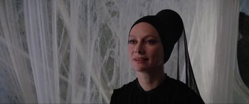 Movie still from “Krull” (1983), directed by Peter Yates – A woman in a black dress and a black hat; Close Up shot, Low angle