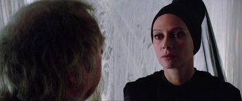 Movie still from “Krull” (1983), directed by Peter Yates – A woman in a black dress looking at a man in a black suit; Close Up shot, Over the shoulder angle