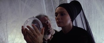 Movie still from “Krull” (1983), directed by Peter Yates – An older man and a young woman looking at a globe; Close Up shot, Low angle