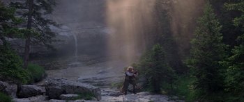 Movie still from “Krull” (1983), directed by Peter Yates – A man and a woman standing in front of a waterfall; Wide shot, Low angle