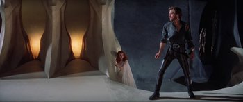 Movie still from “Krull” (1983), directed by Peter Yates – A woman and a man are standing next to each other; Wide shot, Low angle