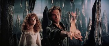 Movie still from “Krull” (1983), directed by Peter Yates – A man and a woman are standing in front of a mountain; Medium shot, Low angle