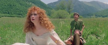 Movie still from “Krull” (1983), directed by Peter Yates – A woman with red curly hair sitting next to a man; Medium shot, Low angle