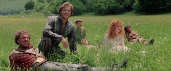 Movie still from “Krull” (1983), directed by Peter Yates – A group of people sitting in the grass; Medium shot, High angle