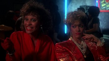 Movie still from “Krush Groove” (1985), directed by Michael Schultz – A couple of people that are posing for a picture; Close Up shot, Over the shoulder angle