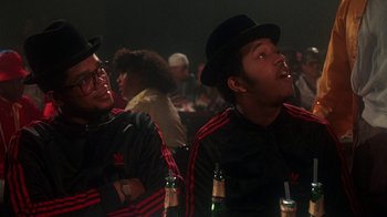Movie still from “Krush Groove” (1985), directed by Michael Schultz – A couple of men sitting next to each other; Close Up shot, Low angle