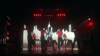 Movie still from “Krush Groove” (1985), directed by Michael Schultz – A group of people standing on a stage with microphones; Wide shot, Low angle