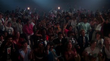 Movie still from “Krush Groove” (1985), directed by Michael Schultz – A large group of people sitting in a room; Wide shot, High angle