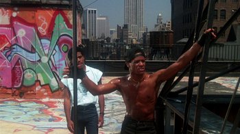 Movie still from “Krush Groove” (1985), directed by Michael Schultz – Two men standing on the roof of a building; Medium shot, Low angle