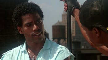 Movie still from “Krush Groove” (1985), directed by Michael Schultz – A man is getting his hair cut by another man; Close Up shot, Low angle