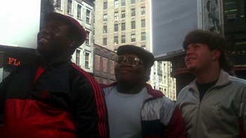 Movie still from “Krush Groove” (1985), directed by Michael Schultz – A group of men standing next to each other on the street; Medium shot, Low angle