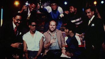 Movie still from “Krush Groove” (1985), directed by Michael Schultz – A group of men posing for a picture; Medium shot, Low angle