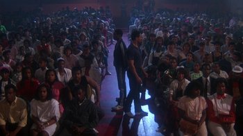 Movie still from “Krush Groove” (1985), directed by Michael Schultz – A crowd of people sitting in a room; Wide shot, High angle