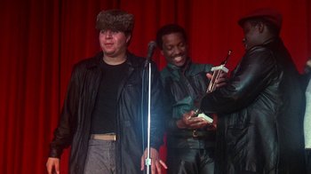 Movie still from “Krush Groove” (1985), directed by Michael Schultz – Two men standing next to each other on a stage; Medium shot, Low angle