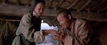 Movie still from “Kundun” (1997), directed by Martin Scorsese – A man and a woman are holding hands; Medium shot, High angle