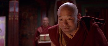 Movie still from “Kundun” (1997), directed by Martin Scorsese – A man in a red and yellow shirt and a man in a red and yellow shirt; Close Up shot, Low angle
