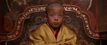 Movie still from “Kundun” (1997), directed by Martin Scorsese – A young boy wearing a yellow and red robe; Close Up shot, High angle