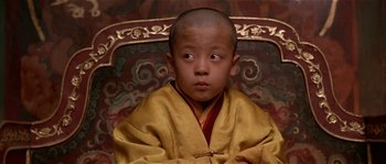 Movie still from “Kundun” (1997), directed by Martin Scorsese – A little boy sitting in a chair wearing a yellow robe; Close Up shot, High angle