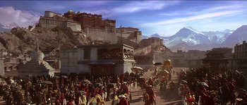 Movie still from “Kundun” (1997), directed by Martin Scorsese – A crowd of people standing on top of a dirt field; Extreme Wide shot, High angle