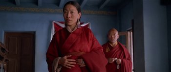 Movie still from “Kundun” (1997), directed by Martin Scorsese – A woman in a red robe standing next to a man in a red robe; Medium shot, Low angle