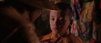 Movie still from “Kundun” (1997), directed by Martin Scorsese – A young boy wearing a yellow shirt looking at a mirror; Close Up shot, Over the shoulder angle