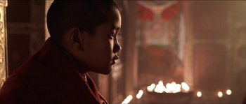 Movie still from “Kundun” (1997), directed by Martin Scorsese – A young boy is looking at the candles in the dark; Close Up shot, Low angle