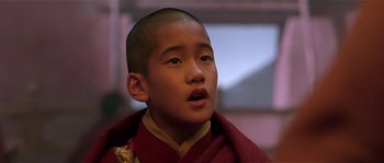 Movie still from “Kundun” (1997), directed by Martin Scorsese – A young boy wearing a red and yellow robe; Close Up shot, Low angle
