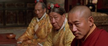 Movie still from “Kundun” (1997), directed by Martin Scorsese – A group of people sitting next to each other; Close Up shot, Over the shoulder angle