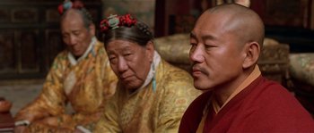 Movie still from “Kundun” (1997), directed by Martin Scorsese – A couple of people sitting next to each other on a couch; Close Up shot, Over the shoulder angle