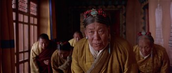 Movie still from “Kundun” (1997), directed by Martin Scorsese – A woman in a yellow jacket with a red flower in her hair; Close Up shot, Low angle