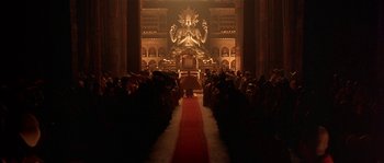 Movie still from “Kundun” (1997), directed by Martin Scorsese – A crowd of people sitting in front of a statue; Extreme Wide shot, High angle