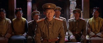 Movie still from “Kundun” (1997), directed by Martin Scorsese – A group of men in military uniforms sitting next to each other; Medium shot, Low angle