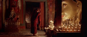 Movie still from “Kundun” (1997), directed by Martin Scorsese – A monk standing in front of a fire place; Wide shot, Low angle
