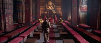 Movie still from “Kundun” (1997), directed by Martin Scorsese – A group of people sitting in a large room; Wide shot, High angle