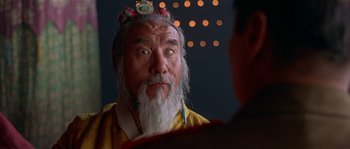 Movie still from “Kundun” (1997), directed by Martin Scorsese – An old man with a long white beard looking at himself in the mirror; Close Up shot, Over the shoulder angle