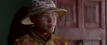 Movie still from “Kundun” (1997), directed by Martin Scorsese – A man wearing a hat and glasses; Close Up shot, Low angle