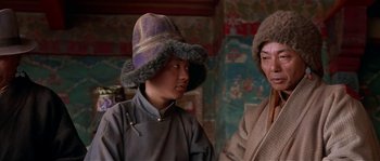 Movie still from “Kundun” (1997), directed by Martin Scorsese – Two people wearing hats and standing next to each other; Close Up shot, Low angle