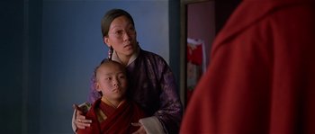 Movie still from “Kundun” (1997), directed by Martin Scorsese – A woman standing next to a young boy in front of a mirror; Close Up shot, Over the shoulder angle