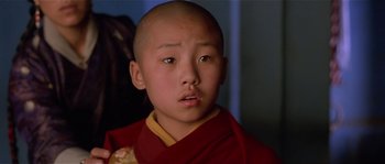 Movie still from “Kundun” (1997), directed by Martin Scorsese – A young boy wearing a red and yellow robe; Close Up shot, High angle
