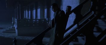Movie still from “Kundun” (1997), directed by Martin Scorsese – A man standing on top of a set of stairs; Wide shot, Low angle