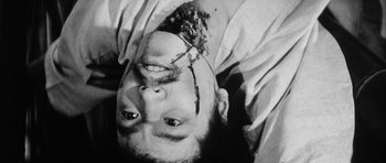 Movie still from “Black Cat” (1968), directed by Kaneto Shindô – A man with a broken head is laying on the ground; Extreme Close Up shot, Overhead angle