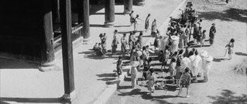 Movie still from “Black Cat” (1968), directed by Kaneto Shindô – A group of people standing on a sidewalk near a building; Extreme Wide shot, High angle