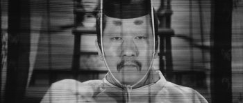 Movie still from “Black Cat” (1968), directed by Kaneto Shindô – A black and white photo of a man with a mustache; Extreme Close Up shot, Overhead angle