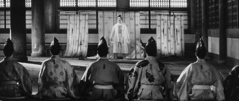 Movie still from “Black Cat” (1968), directed by Kaneto Shindô – A group of men sitting in front of a screen; Wide shot, Low angle