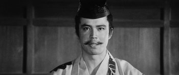 Movie still from “Black Cat” (1968), directed by Kaneto Shindô – A black and white photo of a man wearing a hat; Close Up shot, Low angle