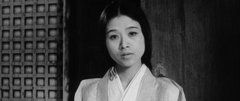 Movie still from “Black Cat” (1968), directed by Kaneto Shindô – A young asian woman in a white shirt and a white robe; Close Up shot, Low angle